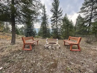 three chairs and a fire pit in a field at Lakeview Mountain Retreat - Private, Modern, Fun in Windermere