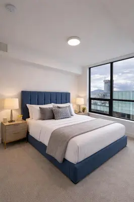 a bedroom with a large bed and a large window at Signature Iconic Lakeview Downtown 2-Bedroom Loft in Kelowna