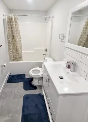 a white bathroom with a toilet and a sink at Private 1BR Suite with Kitchen, Laundry, Parking & 1 Gigabit Internet in Whitehorse