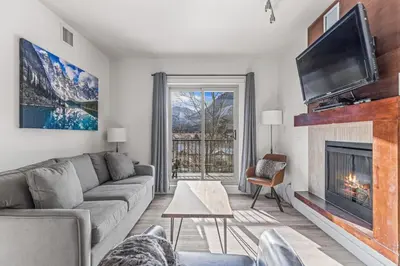 a living room with a couch and a fireplace at Serene 2BR Hideaway Hot Tub and Breathtaking Views in Canmore