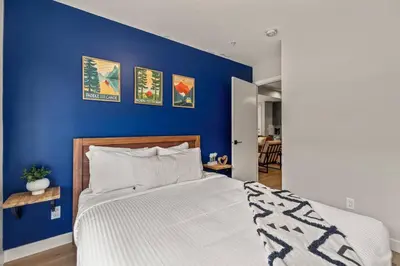 a bedroom with a blue wall with a bed at 3BR Canmore Haven w/ BBQ and free parking in Canmore