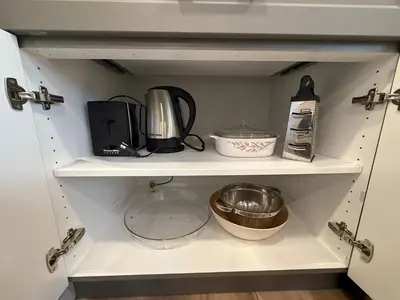 a white cupboard with various kitchen items on it at Fort Home in Fort Saskatchewan
