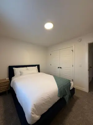 a bedroom with a large bed with white sheets at Fort Home in Fort Saskatchewan
