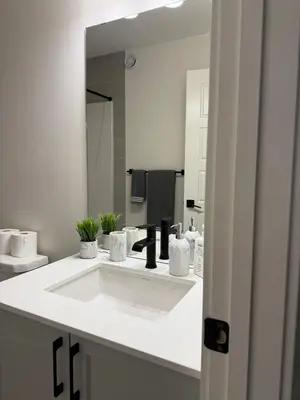 a bathroom with a white sink and a mirror at Fort Home in Fort Saskatchewan