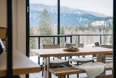 a table and chairs on a balcony with a view at Ridgeline Penthouse by Revelstoke Vacations in Revelstoke