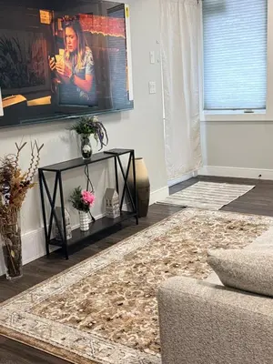 a living room with a couch and a television at Stylish Open Cozy & Contemporary Living Space in Prince George