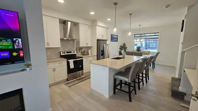 a kitchen with a kitchen island with a counter top at 3 Bedroom Modern Luxury House - Family Friendly, 3 Queen Beds, Free Wi-Fi, and Free Parking in Calgary