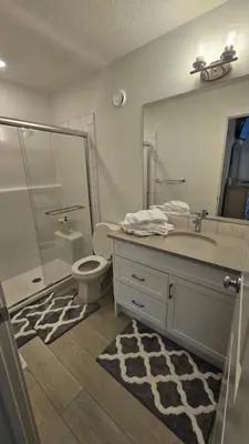 a bathroom with a shower and a toilet and a sink at 3 Bedroom Modern Luxury House - Family Friendly, 3 Queen Beds, Free Wi-Fi, and Free Parking in Calgary