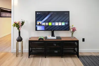 a tv sitting on top of a table with flowers at Modern 3Bed Home with Fireplace, Game Room, and Stylish Comfort Just 12 Minutes from Downtown Calgary in Calgary