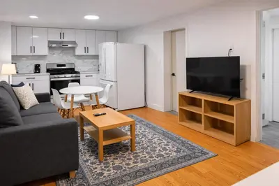 a living room with a couch and a tv and a kitchen at Amalak Homes' Private 2BR Guest Suite North Delta in Delta