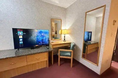 a hotel room with a television and a desk with a mirror at Rychter Hotel Hope in Hope