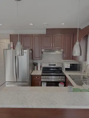 a kitchen with wooden cabinets and stainless steel appliances at Cozy 2 Bdrm suite in the Heart of Renfrew Heights in Vancouver
