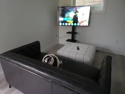 a living room with a couch and a flat screen tv at The Rupert Split Flexible Family Living in Vancouver