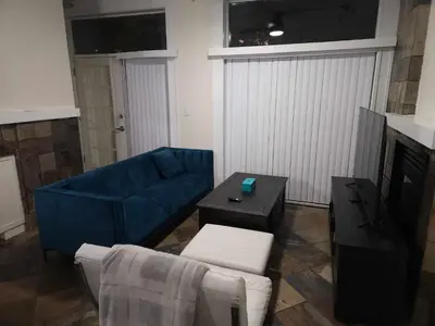 a living room with a blue couch and a table at Vancouver Townhouse Modern 2-Bedroom Retreat in the Heart of Downtown in Vancouver