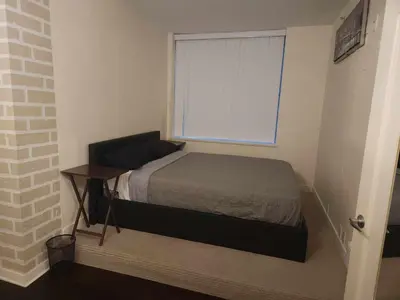 a small bedroom with a bed and a window at Vancouver Townhouse Modern 2-Bedroom Retreat in the Heart of Downtown in Vancouver