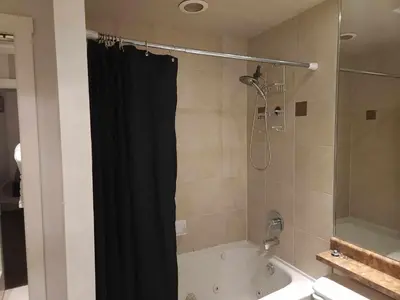 a bathroom with a black shower curtain and a tub at Vancouver Townhouse Modern 2-Bedroom Retreat in the Heart of Downtown in Vancouver