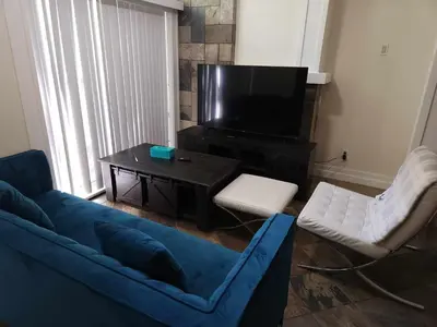 a living room with a blue couch and a tv at Vancouver Townhouse Modern 2-Bedroom Retreat in the Heart of Downtown in Vancouver