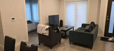 a living room with a couch and a television at UBC Area Gem Spacious 2-Bedroom Townhouse with Full Kitchen in Vancouver