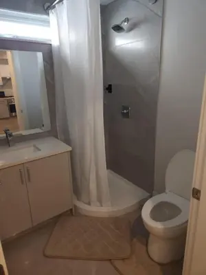a bathroom with a shower and a toilet and a sink at UBC Area Gem Spacious 2-Bedroom Townhouse with Full Kitchen in Vancouver