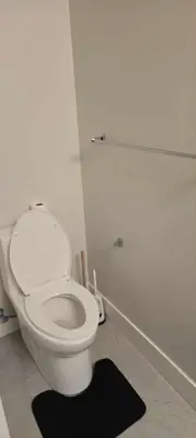 a bathroom with a white toilet and a black rug at UBC Area Gem Spacious 2-Bedroom Townhouse with Full Kitchen in Vancouver