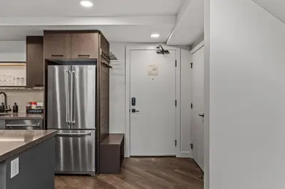 a kitchen with a stainless steel refrigerator and wooden cabinets at Penthouse Loft| 2BD| Mountain Views| Pool + HotTub in Canmore