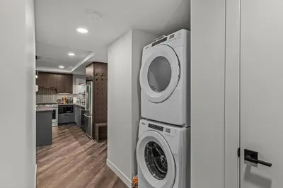 a laundry room with a washer and dryer at Penthouse Loft| 2BD| Mountain Views| Pool + HotTub in Canmore