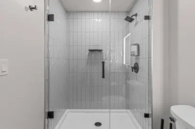 a shower with a glass door in a bathroom at Premier Suite | Mountain Views | Sleeps 10 in Canmore