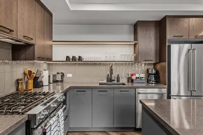a kitchen with stainless steel appliances and wooden cabinets at Premier Suite & Penthouse Loft - Sleeps 16 in Canmore