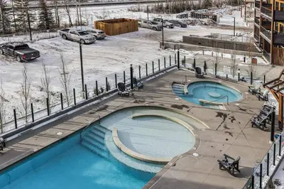 a large swimming pool with snow on the ground at Premier Suite & Penthouse Loft - Sleeps 16 in Canmore