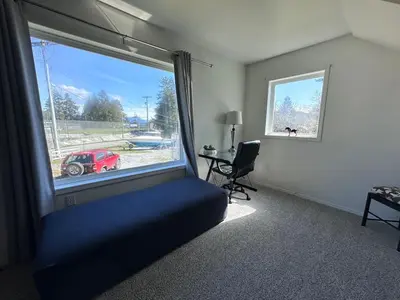 a bedroom with a window with a red car outside at Texada Hunter Hiker friendly suite in Vananda