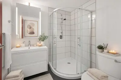 a white bathroom with a shower and a sink at Bright and Comfortable 2BR Downtown Apartment for Families and Groups in Vancouver