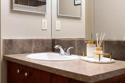 a bathroom counter with a sink and a mirror at Panorama Hills Cozy Guest Suite in Calgary