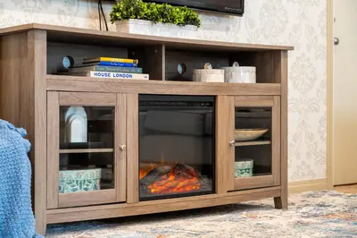 a wooden entertainment center with a fire in it at Panorama Hills Cozy Guest Suite in Calgary