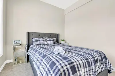 a bedroom with a bed with two towels on it at 2 Bedroom Smart Secondary Suite with Gazebo view in Calgary