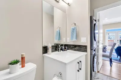 a white bathroom with a sink and a mirror at 2 Bedroom Smart Secondary Suite with Gazebo view in Calgary