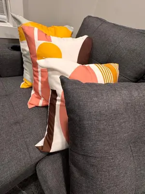 a gray couch with colorful pillows on it at NorthEdge Master Suite, Leduc in Leduc