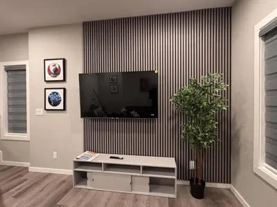 a living room with a tv on a wall at NorthEdge Master Suite, Leduc in Leduc
