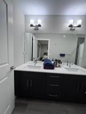 a bathroom with two sinks and a large mirror at NorthEdge Master Suite, Leduc in Leduc