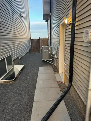 a house with a hose hooked up to a building at Cozy 2 Bedroom Basement Apartment in Calgary