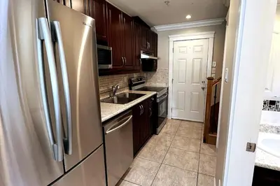 a kitchen with a stainless steel refrigerator and a sink at A Cozy Nest, Private Tiny Home in Vancouver
