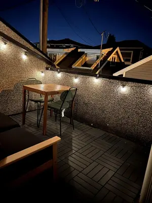 a wooden table and chairs on a patio with lights at A Cozy Nest, Private Tiny Home in Vancouver