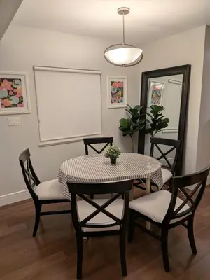 a dining room with a table and chairs and a whiteboard at Designer 2-Bedroom Garden-Level Walk-Out Suite in Surrey