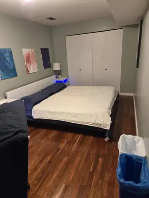 a bedroom with a large bed and a wooden floor at Private Entrance OFFICE SPACE King Suite in Mission City