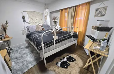 a bedroom with a bed with two dogs laying on the floor at Bohemian Theme Private Room near Metrotown Mall with private parking in Burnaby