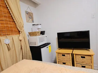 a living room with a television and a microwave at Bohemian Theme Private Room near Metrotown Mall with private parking in Burnaby