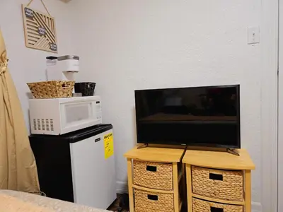 a tv sitting on top of a table with a microwave at Bohemian Theme Private Room near Metrotown Mall with private parking in Burnaby