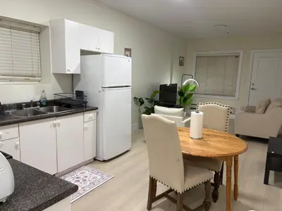 a kitchen with a table and a white refrigerator at Cozy Home in Surrey