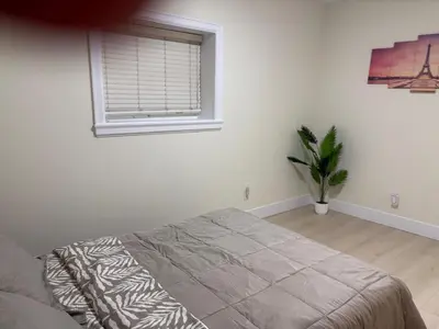 a white bedroom with a bed and a window at Cozy Home in Surrey