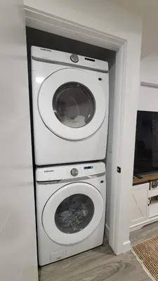 a washer and dryer in a corner of a room at 2BR 14minsYYC Airport Private Entrance Soft Water System in Calgary