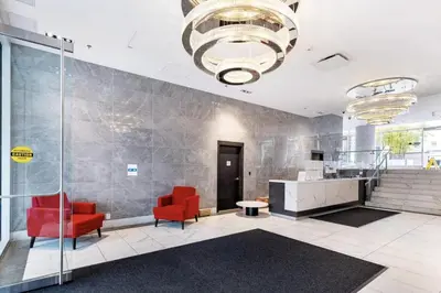 a lobby with two red chairs and a chandelier at 25 Days Minimum - Luxury and Modern Downtown Apartment - Do not send request for less than 21 days in Vancouver
